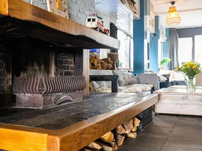a fireplace in a living room with a couch at De Kaag Watersport Groepsaccommodatie - 50 pers in Kaag