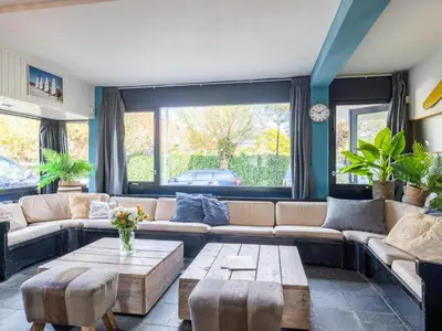 a living room with a couch and a table at De Kaag Watersport Groepsaccommodatie - 50 pers in Kaag