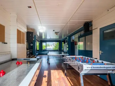 a row of ping pong tables in a room at De Kaag Watersport Groepsaccommodatie - 50 pers in Kaag