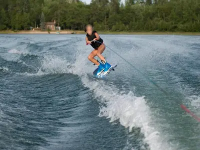 a woman is water skiing on the water at De Kaag Watersport Groepsaccommodatie - 50 pers in Kaag