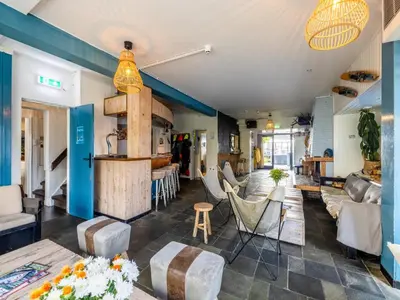 a living room with a couch and chairs at De Kaag Watersport Groepsaccommodatie - 50 pers in Kaag