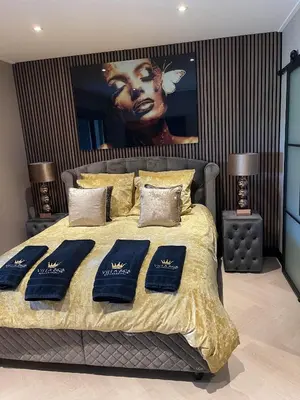 a bedroom with a large bed with a poster on the wall at Villa B&B Bovenkarspel in Bovenkarspel