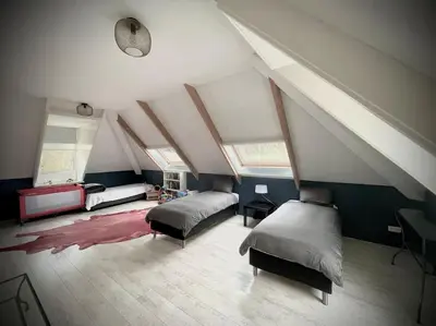a attic room with two beds and a bed istg at Luxe vakantievilla met jacuzzi in Zeewolde