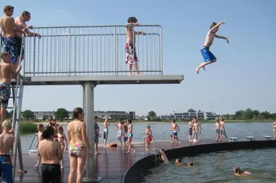 a group of people in the water at the beach at Luxe vakantievilla met jacuzzi in Zeewolde