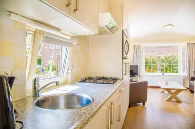 a kitchen with a sink and a stove at Vakantiepark Duinrust in Noordwijk