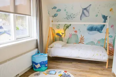 a childs room with a bed and a window at Vakantiepark Duinrust in Noordwijk