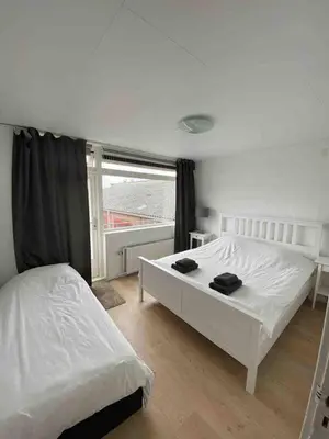 a bedroom with two white beds and a window at Nice Spacious House Near Amsterdam And Schiphol in Zwanenburg