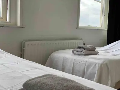 a bedroom with a bed with towels on it at Nice Spacious House Near Amsterdam And Schiphol in Zwanenburg