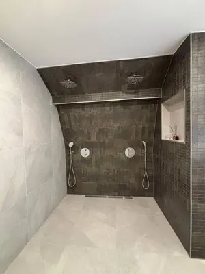 a bathroom with two showers and a tiled wall at Luxury 6pers appartement Abcoude in Abcoude
