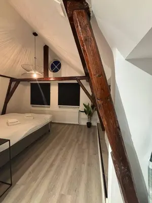 a attic room with a bed and two windows at Luxury 6pers appartement Abcoude in Abcoude