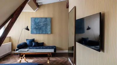 a living room with a blue couch and a mirror at Morgan & Mees Amsterdam in Amsterdam