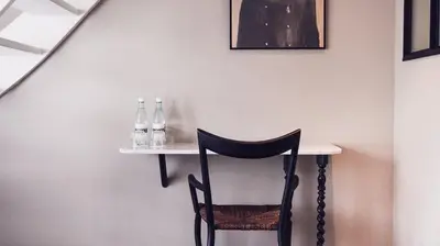 a table with a chair and bottles on a wall at Morgan & Mees Amsterdam in Amsterdam