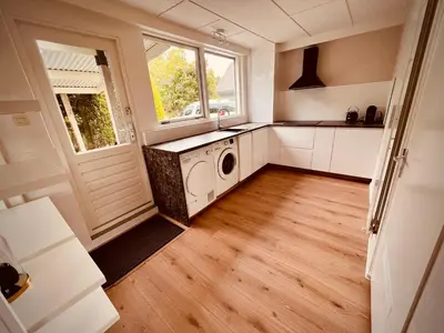 a laundry room with a washer and dryer in it at Aan de dijk in Dirkshorn