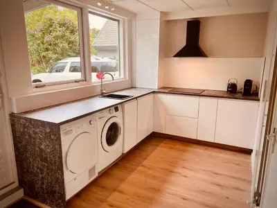 a kitchen with a washing machine and a window at Aan de dijk in Dirkshorn