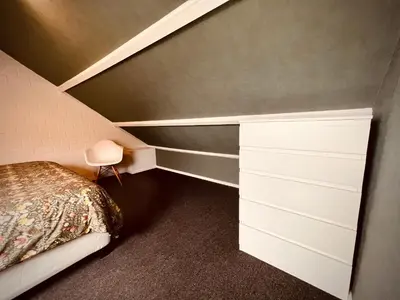 a small bedroom with a bed and a shelf at Aan de dijk in Dirkshorn