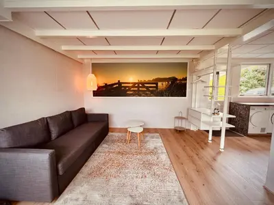 a living room with a couch and a painting on the wall at Aan de dijk in Dirkshorn