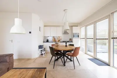 a kitchen and dining room with a wooden table and chairs at Zonlicht by Droomvilla in Egmond aan Zee