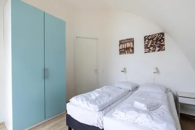 two beds in a room with white walls at Zonlicht by Droomvilla in Egmond aan Zee