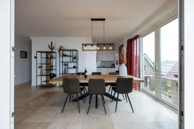 a dining room with a wooden table and chairs at Sterrenlicht by Droomvilla in Egmond aan Zee