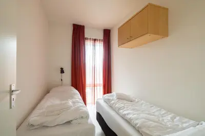 a room with two beds in front of a window at Sterrenlicht by Droomvilla in Egmond aan Zee