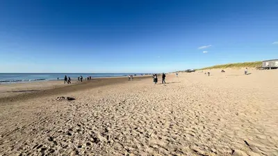 a group of people walking on a beach at Sterrenlicht by Droomvilla in Egmond aan Zee