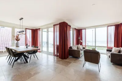 a living room with a table and chairs and a couch at Sterrenlicht by Droomvilla in Egmond aan Zee