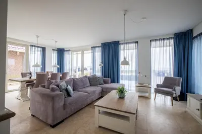 a living room with a couch and a table at Zilverlicht by Droomvilla in Egmond aan Zee