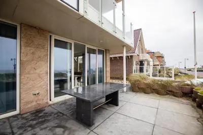 a black bench sitting on the side of a building at Zilverlicht by Droomvilla in Egmond aan Zee