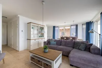 a living room with a couch and a table at Zilverlicht by Droomvilla in Egmond aan Zee