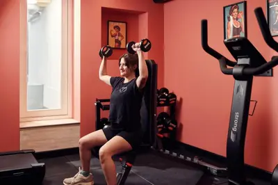 a woman lifting weights in a gym at The Elephant Hostel in Amsterdam
