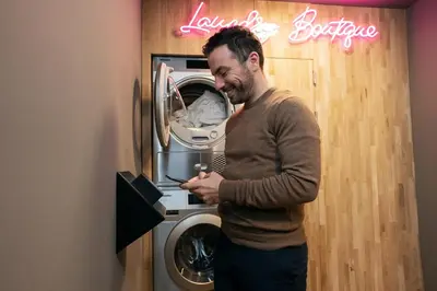 a man standing in front of a washing machine at The Elephant Hostel in Amsterdam