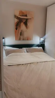 a bedroom with a bed with a painting on the wall at Joysea Appartments in Zandvoort