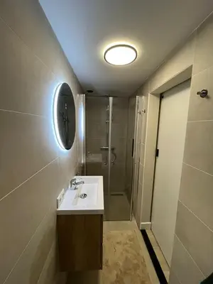 a bathroom with a shower and a sink and a mirror at Joysea Appartments in Zandvoort