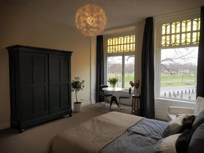 a bedroom with a bed and a table and a chandelier at M-Square in Amsterdam