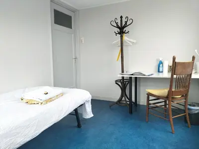 a bedroom with a bed and a desk and a chair at Historic canal house in green residential area in Utrecht
