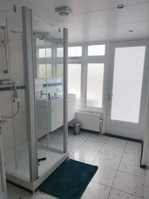 a bathroom with a shower and a tub and a sink at Historic canal house in green residential area in Utrecht