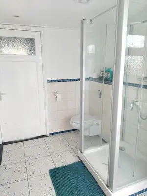 a bathroom with a glass shower and a toilet at Historic canal house in green residential area in Utrecht