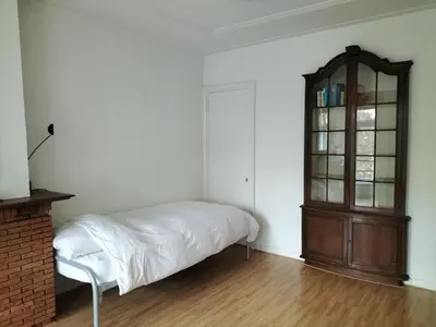 a bedroom with a bed and a wooden cabinet at Historic canal house in green residential area in Utrecht