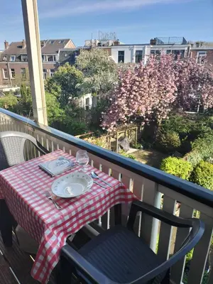 a table with a plate of food on a balcony at Historic canal house in green residential area in Utrecht
