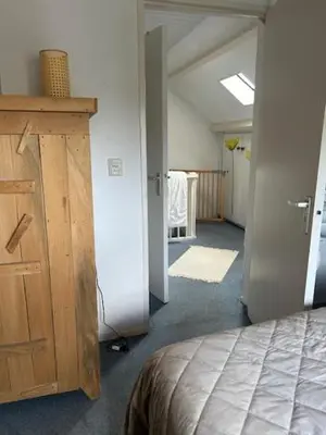a room with a bed and a closet and a hallway at BeJa bij strand en duin in Egmond aan Zee