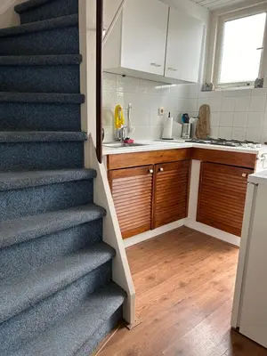 a kitchen with a staircase leading up to a kitchen at BeJa bij strand en duin in Egmond aan Zee