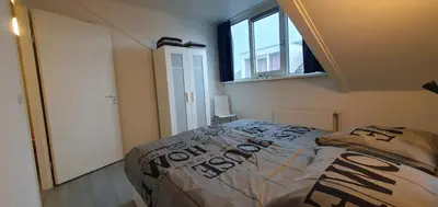 a bedroom with a bed and a window at Appartement Uniekappart in Uitgeest