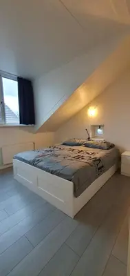 a bedroom with a large bed in a room at Appartement Uniekappart in Uitgeest