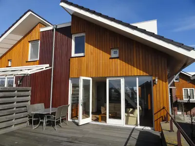 a house with glass doors and a patio at Appartement Uniekappart in Uitgeest