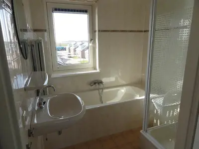 a bathroom with a sink and a tub and a window at Appartement Uniekappart in Uitgeest