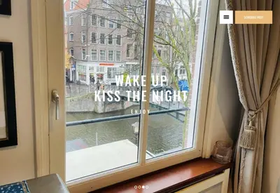a window with a sign that reads wake up kiss the night at redlight canalview city centre in Amsterdam