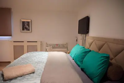 a bedroom with a bed with green pillows and a television at redlight canalview city centre in Amsterdam