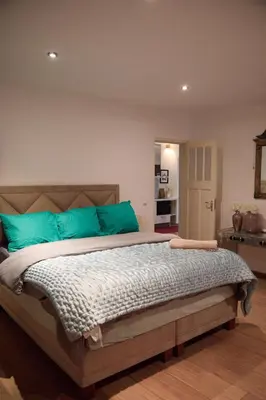 a bedroom with a large bed with blue pillows at redlight canalview city centre in Amsterdam