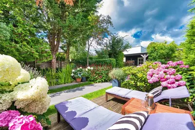 a backyard with a garden with pink and white flowers at B&B Hoofddorp in Hoofddorp