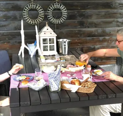 two people sitting at a picnic table with food at B&B Hoofddorp in Hoofddorp